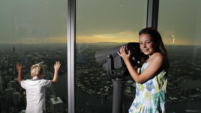 Zoe Lynch and her brother Jay from the UK watch a storm come across the Gold Coast from the Skypoint observation deck of the Q1 in Surfers Paradise. Picture: Jerad Williams