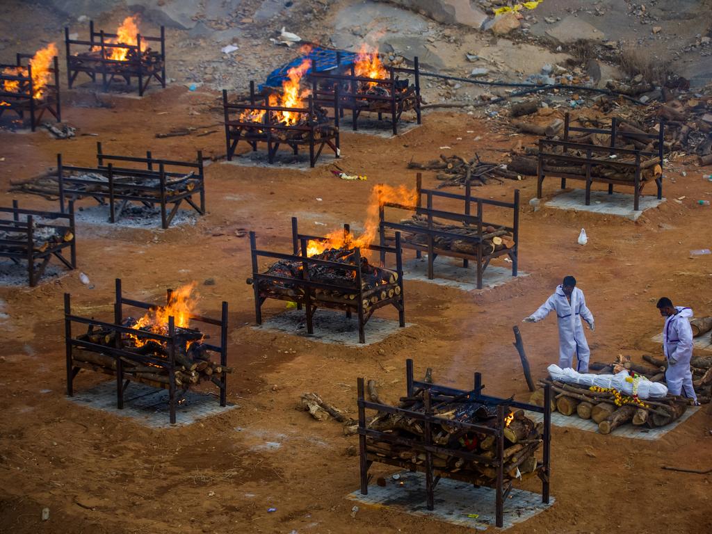 Men perform the last rites of a deceased relative in a disused granite quarry repurposed to cremate COVID-19 victims in Bengaluru, India. Picture: Abhishek Chinnappa/Getty Images