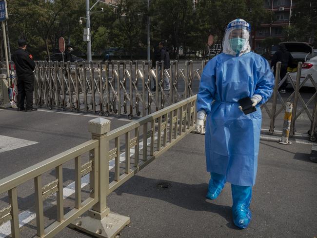 An epidemic control worker walks away from a barrier fence after dropping off samples taken to detect Covid-19 from journalists, staff, and officials. Picture: Kevin Frayer/Getty Images