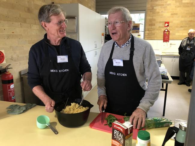 Bruce Johnson (right) with Peter Osborne, finish off the Moroccan chicken dish during a Men's Kitchen Northern Beaches cooking skills session at the Forestville Community Hall on Friday. Picture: Jim O'Rourke