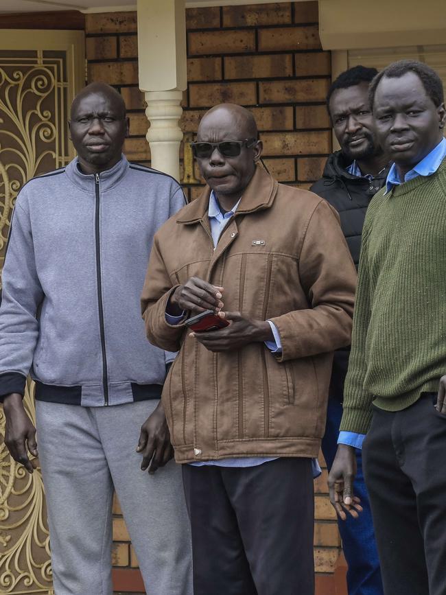 Family members gather outside Atem Kuany’s home with his father Elijah (third from right). Picture: Roy VanDerVegt