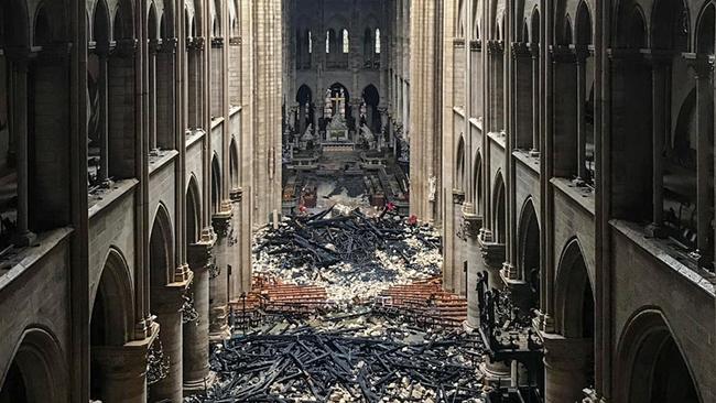 The morning after the fire: the ‘forest’ of 1000-year-old, 100m-long oak beams that held up the roof collapsed on to the pews in the cathedral. Picture: AFP