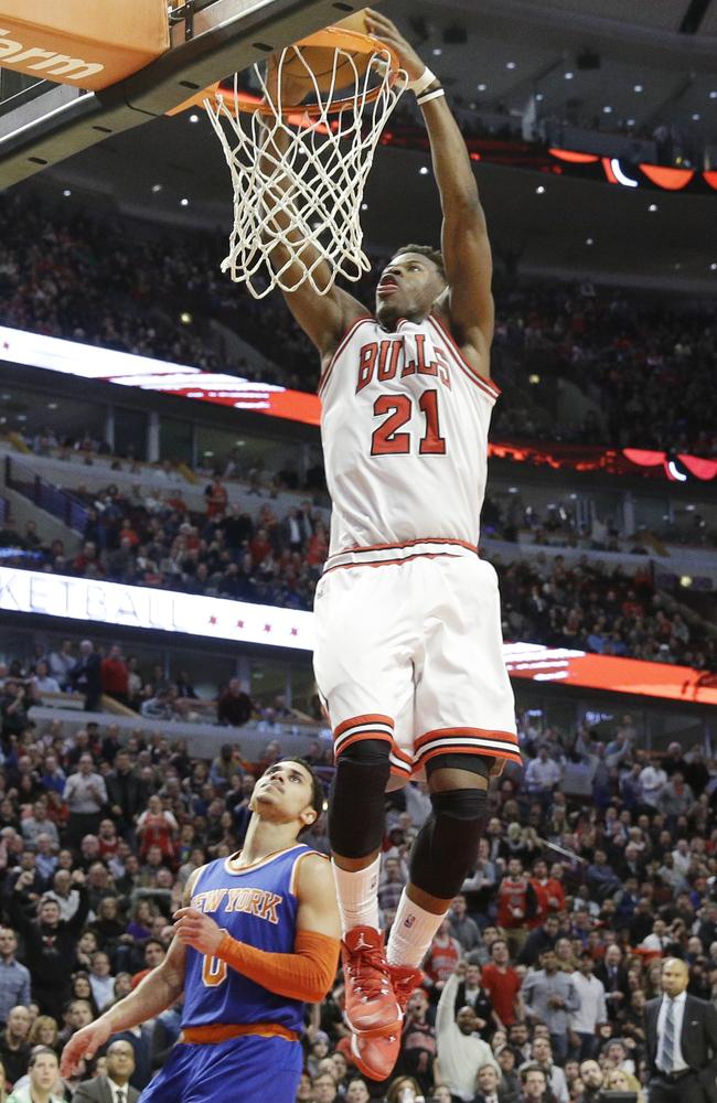 Bulls guard Jimmy Butler dunks as Shane Larkin looks on.