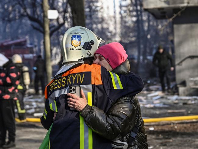 A fireman embraces a woman outside a damaged apartment building in Kyiv on March 15. Picture: Aris Messinis / AFP