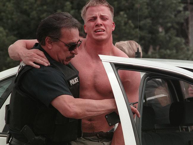 Horror day ... A police officer helps a wounded student at the scene near the Columbine High School in Littleton, Denver Colorado on April 20, 1999. Picture: AP/George Kochaniec/RockyMountainNews.