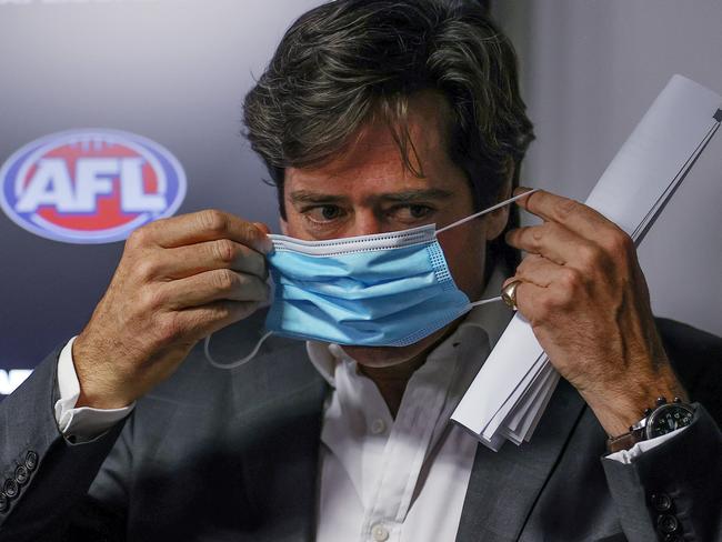 AFL CEO Gillon McLachlan dons a mask at a press conference last year. Picture: Michael Klein