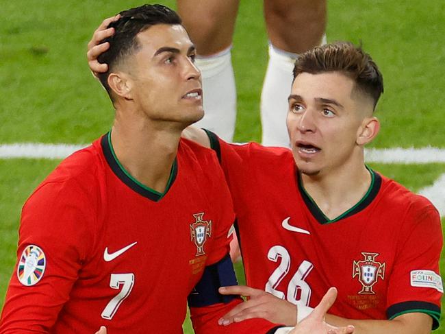 Portugal's forward #07 Cristiano Ronaldo and Portugal's forward #26 Francisco Conceicao react during the UEFA Euro 2024 quarter-final football match between Portugal and France at the Volksparkstadion in Hamburg on July 5, 2024. (Photo by Odd ANDERSEN / AFP)