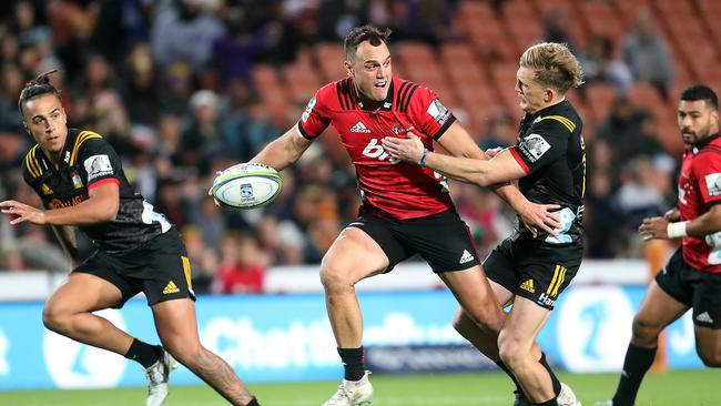 Crusaders fullback Israel Dagg is tackled by Chiefs five-eighth Damian McKenzie.