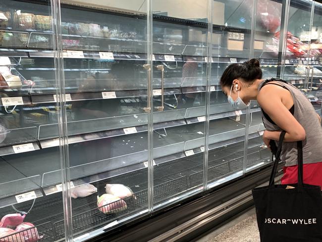 12/01/2022 A customer looks into the empty meat section of the Coles in St Kilda. Aaron Francis/Herald Sun