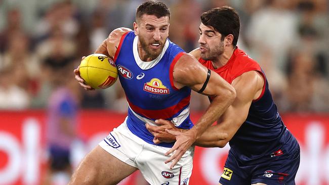 Bulldog Marcus Bontempelli tries to charge through the Christian Petracca of the Demons in the AFL’s round one. Pic: Michael Klein