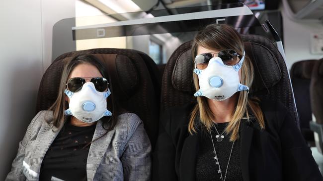 MILAN, ITALY – FEBRUARY 25: Two passengers wear protective masks as they travel on a train from Rome to Milan. Picture: Marco Di Lauro/Getty