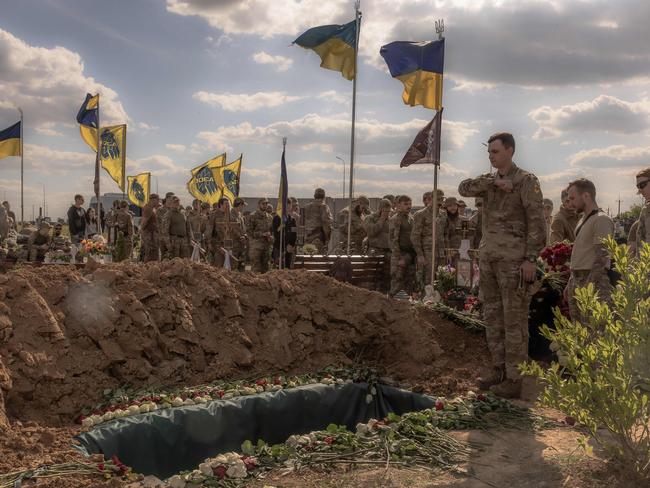 Azov Brigade fighters pay their respect at the grave of Nazary Gryntsevych, a Ukrainian soldier of the Azov Brigade callsigned "Grinka" who was killed on the battlefield, during a funeral ceremony at a football stadium in Vinnytsia, on May 10, 2024, amid the Russian invasion of Ukraine. "Grinka" was one of the youngest soldiers to hold the Azovstal still plant in the southern city of Mariupol during a three-month-long siege that gave its defenders a cult status.Â Russian troops ended up seizing Mariupol in May 2022 and capturing Gryntsevych, before allowing him to return as part of a prisoner deal. Later Gryntsevych was back on the battlefield. (Photo by Roman PILIPEY / AFP)