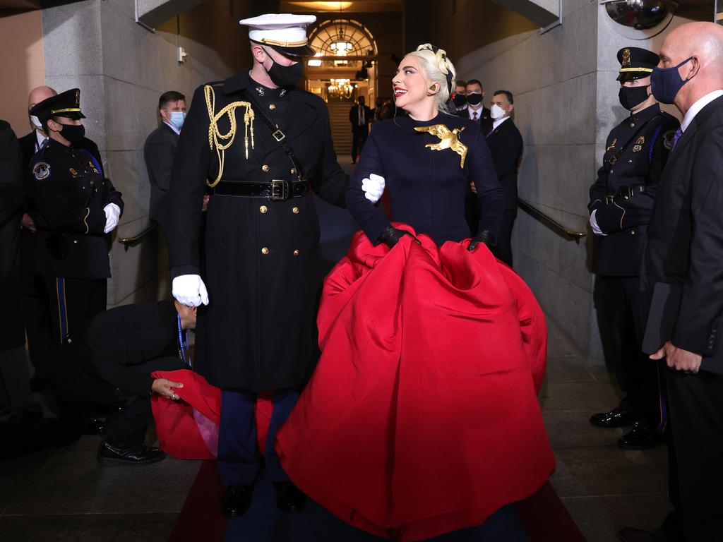 Lady Gaga was a vision in red and black – complete with Hunger Games-style gold peace dove brooch – as she arrives to sing the national anthem. Picture: Win McNamee/Getty Images