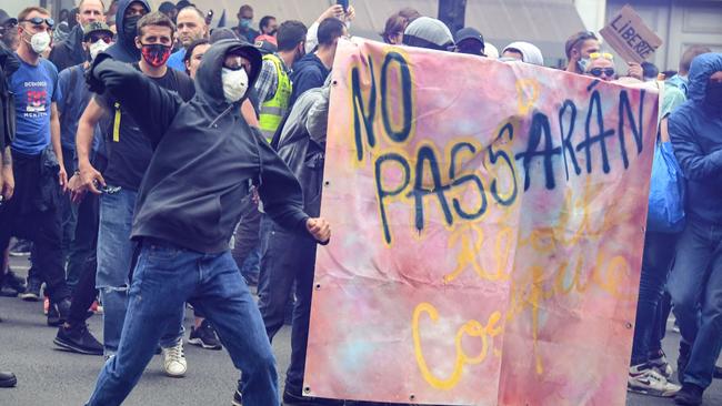 Demonstrators clash with police in Paris as part of a national day of protest against French legislation making a Covid-19 health pass compulsory to visit a cafe, board a plane or travel on an inter-city train. Picture: AFP