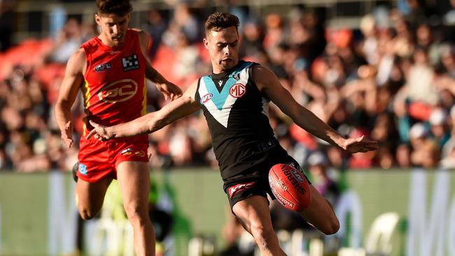 Karl Amon gives his opponent the slip as Port made easy work of the Gold Coast at Metricon Stadium. Picture: AFL Photos/via Getty Images