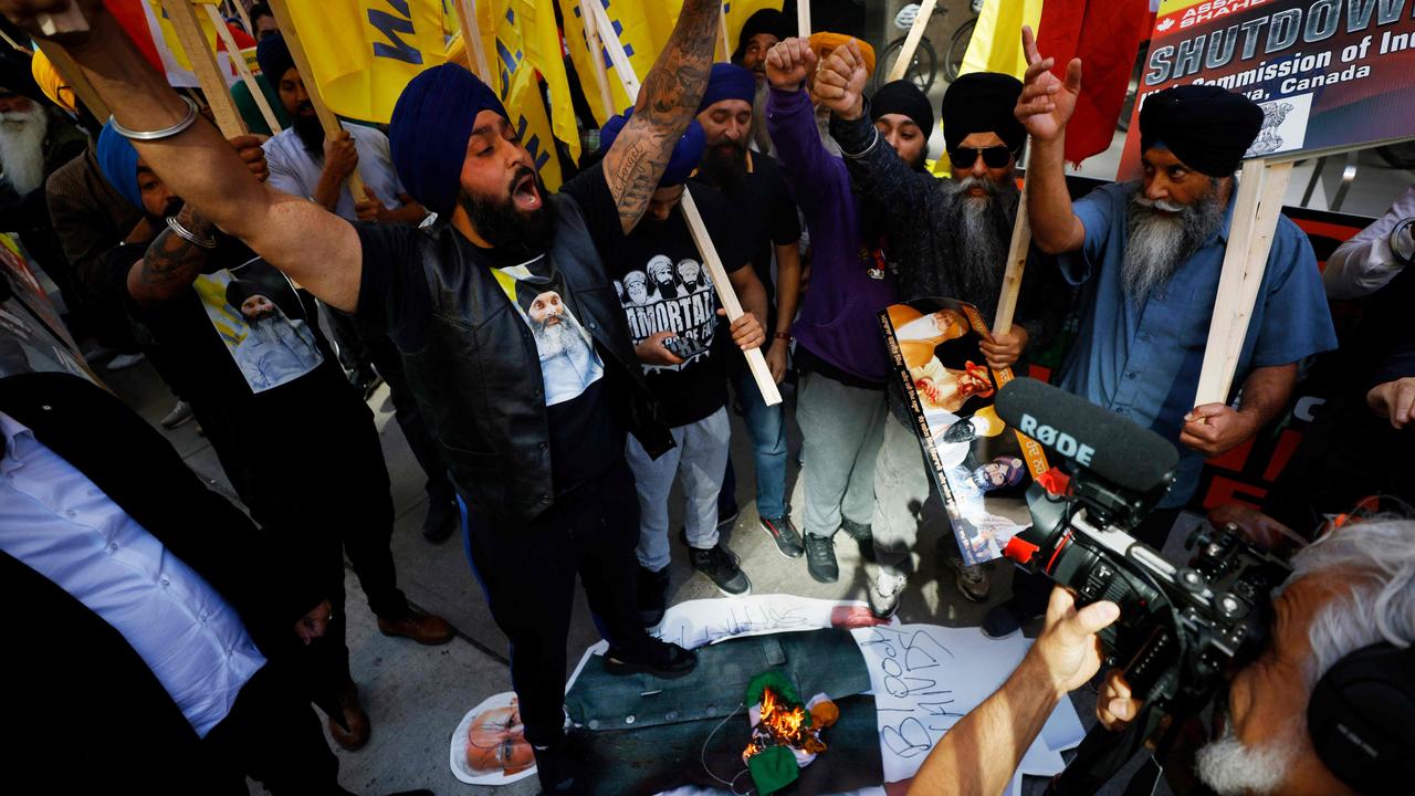 Demonstrators burn an Indian flag and deface a placard depicting Indian prime minister Narendra Modi during a Sikh rally outside the Consulate General of India, in Toronto. Picture: Cole Buston/AFP