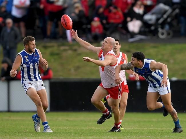 Karingal champion Michael Burke coaxes the ball his way against Langwarrin on Saturday. Picture: Andy Brownbill