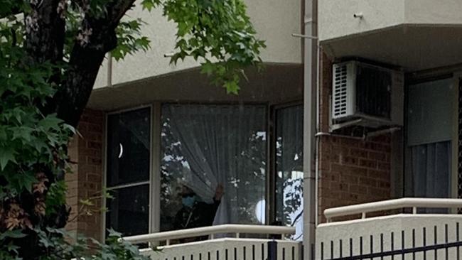 Residents could be seen peering out of windows in the Baptist Care complex in Macquarie Park on Monday. It comes after a third resident died after contracting coronavirus at the weekend. Picture: Nicole Pierre