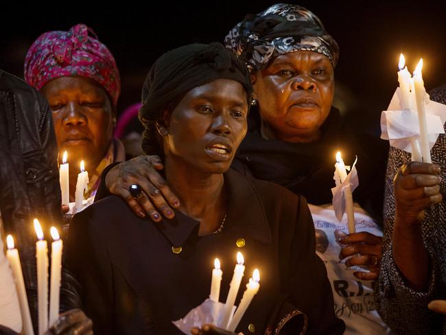 Akon Guode is comforted by family and friends. Picture: Ian Currie