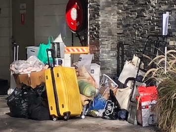 Residents gather their belongings this morning after being granted temporary access to their homes. Picture: Phoebe Loomes