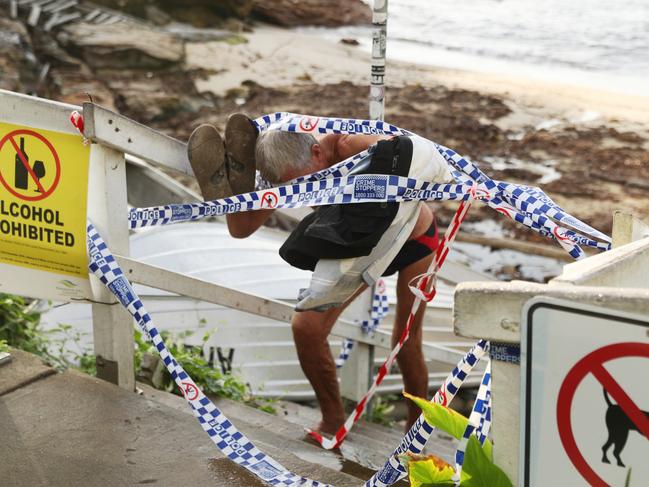 Police tape blocks the entry to Gordon’s Bay beach but people were seen climbing through to enjoy a swim last week. Picture: John Grainger