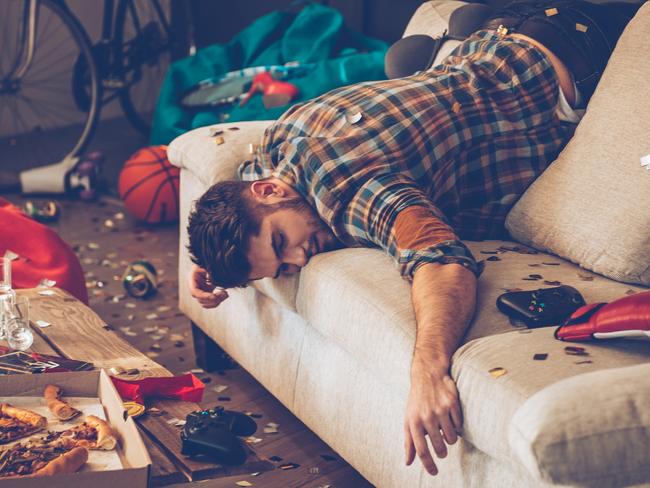 Young handsome man passed out on sofa in messy room after party Aribnb wild parties generic istock photo