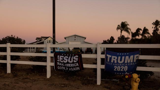 Flags reading “Jesus Make America Godly Again and “Trump 2020” are displayed on the fence of a house in California. Picture: AFP