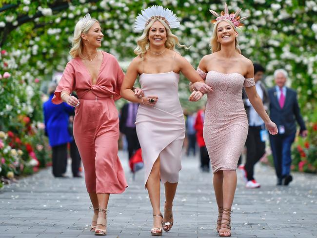 Sisters Chrissy Thomas, Amy-Lee Seward and Kirsty Seward aren’t letting the wet weather ruin their day. Picture: Jason Edwards