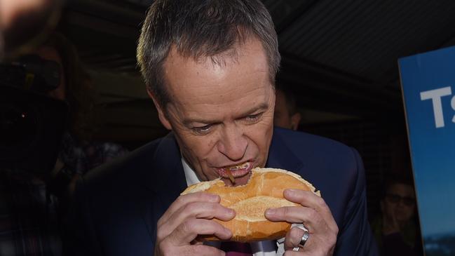 Bill Shorten eats a sausage sandwich in 2016. Picture: AAP Image/Mick Tsikas