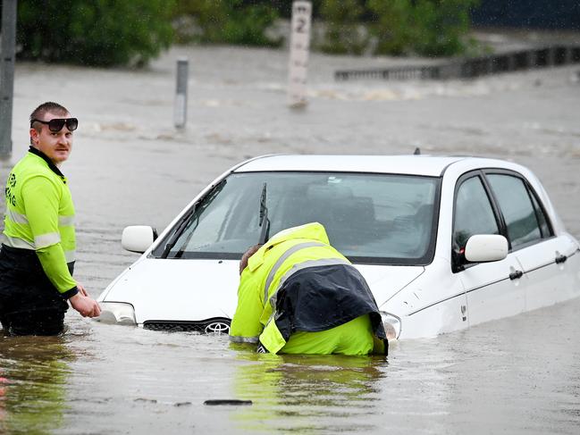 BRISBANE, AUSTRALIA - NewsWIRE Photos FEBRUARY 16, 2024:  Tow truck drivers get a Car out of flooded water in Widdop st, Nundah. Wild and Wet weather in Brisbane.Picture: NCA NewsWIRE / John Gass