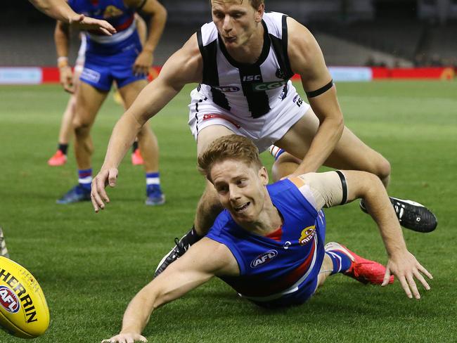 AFL Round 1. Western Bulldogs v Collingwood at Marvel Stadium..  21/03/2020.   Lachie Hunter of the Bulldogs battles at ground level with Will Hoskin-Elliott of the Magpies   . Pic: Michael Klein