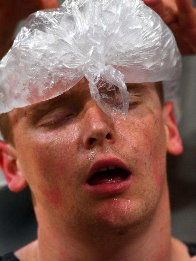 Australia's Jesse Costelloe has ice on his head while competing in the men's indoor rowing. Picture: Saeed Khan/AFP