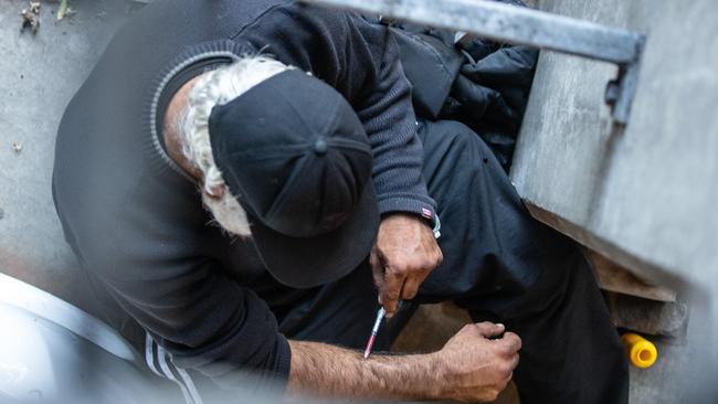 A drug user injecting in a carpark next to the medically supervised injecting room. Picture: Sarah Matray