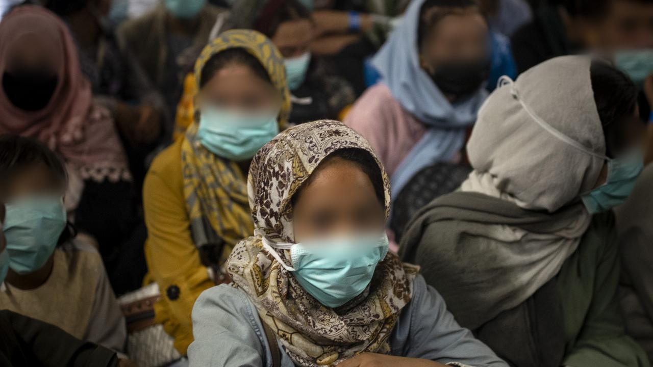 Afghan families board the Royal Australian Air Force C-17A Globemaster III aircraft, prior to departing from Hamid Karzai International Airport in Kabul, Afghanistan.