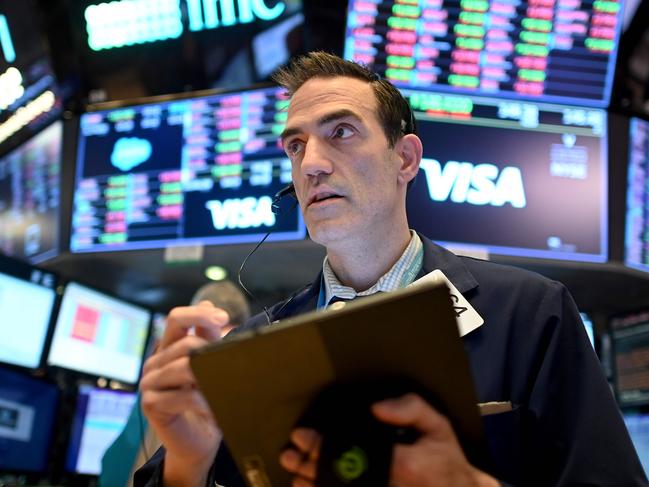 (FILES) In this file photo Traders work during the closing bell at the New York Stock Exchange (NYSE) on March 18, 2020 at Wall Street in New York City. - Wall Street stocks jumped early March 25, 2020 as markets awaited a vote on a $2 trillion package agreed by congressional leaders to boost the US economy ravaged by the coronavirus outbreak.About 15 minutes into trading, the Dow Jones Industrial Average was up 2.6 percent, or around 540 points, at 21,244.77. (Photo by Johannes EISELE / AFP)