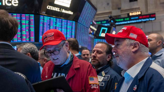 Traders watch as President-elect Donald Trump walks onto the floor of the New York Stock Exchange with his wife, Melania, after being named Time magazine’s Person of the Year the second time on December 12. Picture: Spencer Platt/AFP