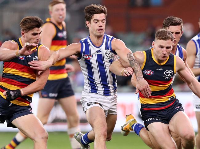 ADELAIDE, AUSTRALIA - AUGUST 22: Jy Simpkin of the Kangaroos tries to hold back crows players Ben Keays and Rory Laird during the 2021 AFL Round 23 match between the Adelaide Crows and the North Melbourne Kangaroos at Adelaide Oval on August 22, 2021 in Adelaide, Australia. (Photo by Sarah Reed/AFL Photos via Getty Images)