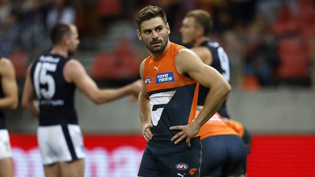 A frustrated Stephen Coniglio after the Giants’ loss to the Blues, with Sam Docherty and Patrick Cripps celebrating their unbeaten start to the season. Picture: Phil Hillyard