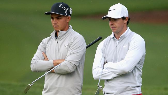 Rickie Fowler and Rory McIlroy wait on the 10th green.