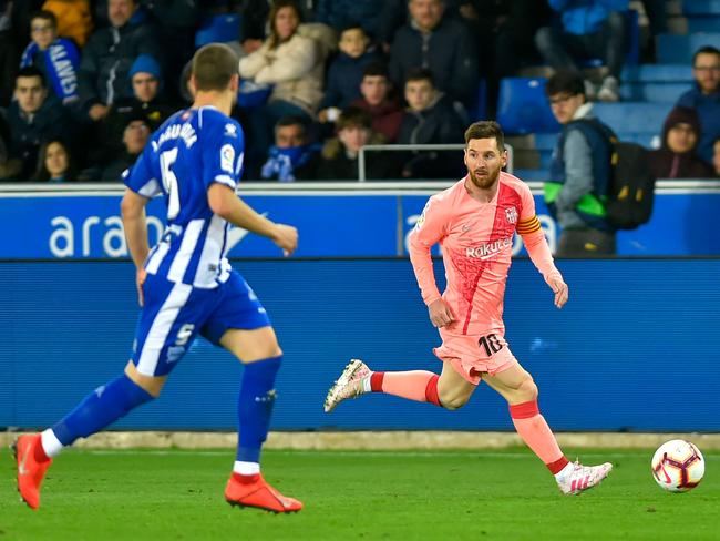 Barcelona's Argentinian forward Lionel Messi (R) runs with the ball during the Spanish league football match between Deportivo Alaves and FC Barcelona at the Mendizorroza stadium in Vitoria. Picture: Ander Gillenea