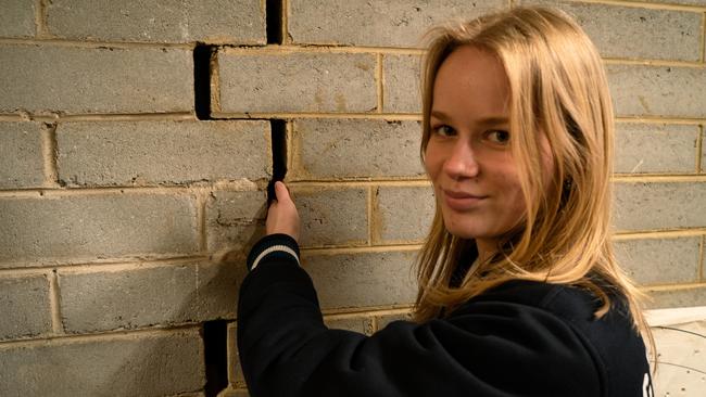 Elwood College school captain Lily with one of the cracks in the wall. Picture: Supplied