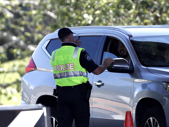 COOLANGATTA, AUSTRALIA - DECEMBER 21: Police officer speaks to a motorists who is entering Queensland from New South Wales through the border checkpoint on December 21, 2020 in Coolangatta, Gold Coast, Australia. Queensland has closed its border to greater Sydney residents as a cluster of Covid-19 cases continues to increase. Queensland residents returning from Sydney have until 1am on Tuesday get home. (Photo by Regi Varghese/Getty Images)