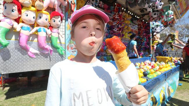 Isabella Bowlay enjoying a dagwood dog. Photo by Richard Gosling