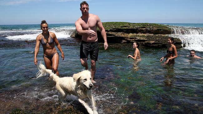 Sarah Kelly and Ross Dunne revel in the chance to take Paris the golden retriever for a dip at Bronte Beach rockpools in Sydney’s east on Sunday. Picture: Jane Dempster