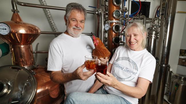 Ray and Sarah Lewis in their distillery with their chook Doris. Picture: Annette Dew
