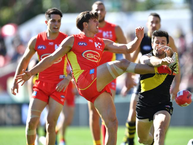 David Swallow (centre) of the Suns has his kick smothered during the Round 21 AFL match between the Gold Coast Suns and the Richmond Tigers at Metricon Stadium on the Gold Coast, Saturday, August 11, 2018. Picture: AAP Image, Darren England.