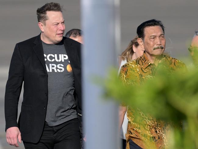 Tech billionaire Elon Musk walks with Indonesia’s Luhut Binsar Pandjaitan. Picture: AFP