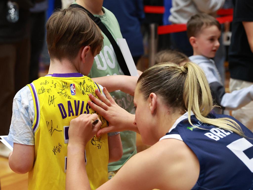 Elissa Brett signs a young fan’s jumper after a match. Picture: Kelly Defina/Getty Images