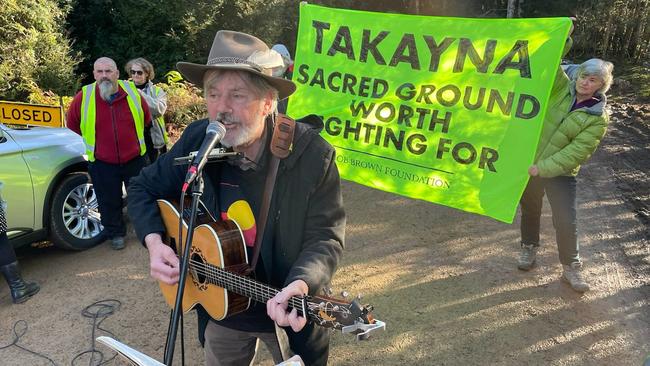 Shane Howard sings to protesters in the rainforest near Rosebery.