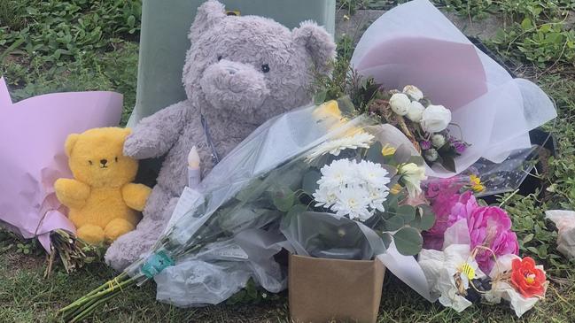 Stuffed toys, flowers and messages from the community have begun to collect outside the suburban home on Regency Rd.